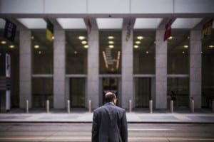 businessman in front of empty street across from office building